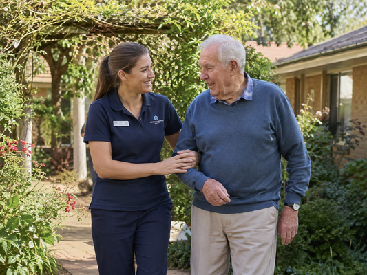 Aged care worker walking with a resident in a garden, cover photo for the When Should I Complete an Incident Report guide
